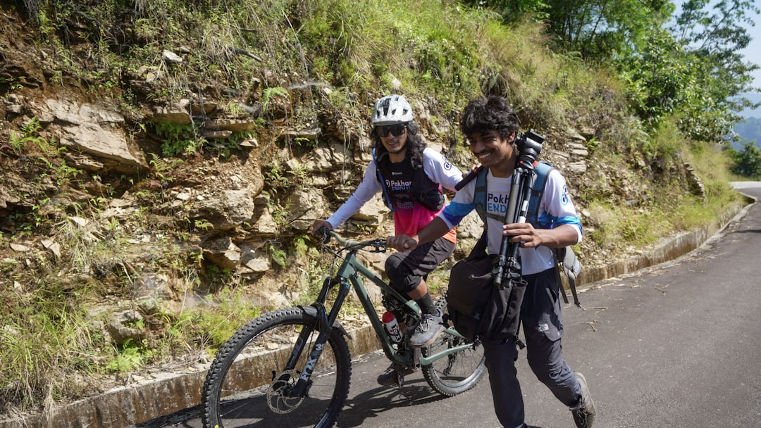 Two people cycling and running on a paved road